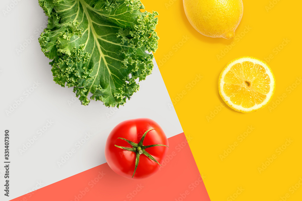 由羽衣甘蓝、番茄、柠檬在明亮的背景上制成的创意布局。平面布局。食品概念。宏观