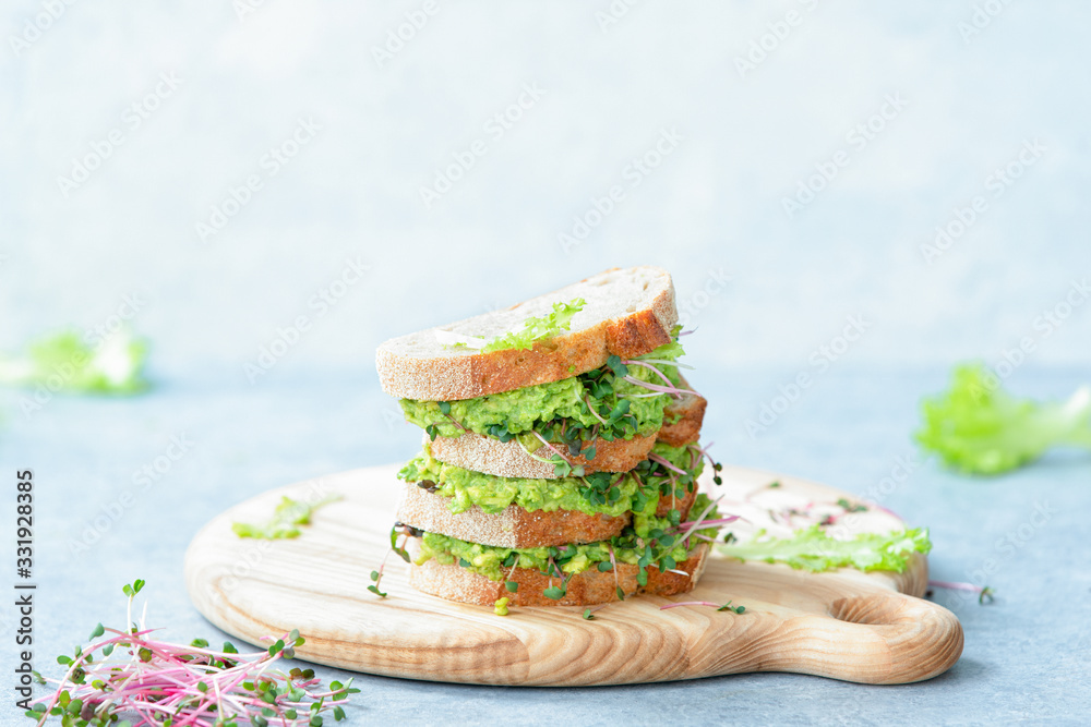 Avocado and green sprouts salad sandwiches, healthy eating concept, front view