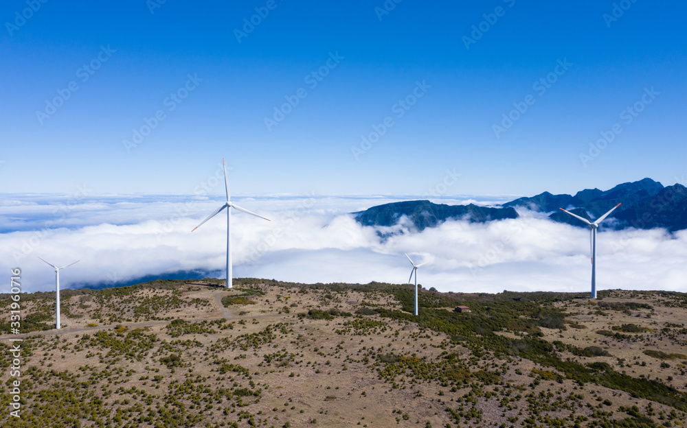 a山脉晴朗的夏日，云层背景和蓝天的风力发电机