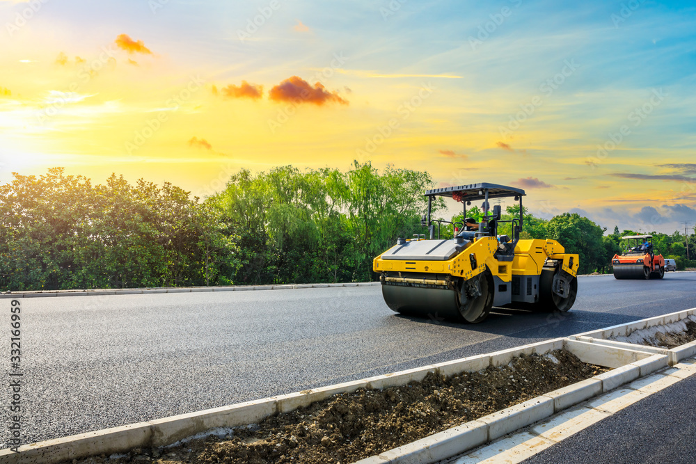 施工现场正在铺设新的沥青路面，道路施工人员和道路施工人员