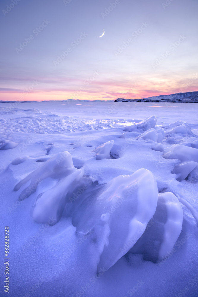 彩色日落期间贝加尔湖结冰的冬季景观。俄罗斯西伯利亚贝加尔湖