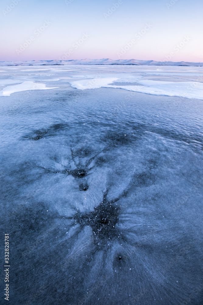 日出时贝加尔湖结冰的冬季景观。俄罗斯西伯利亚贝加尔湖。