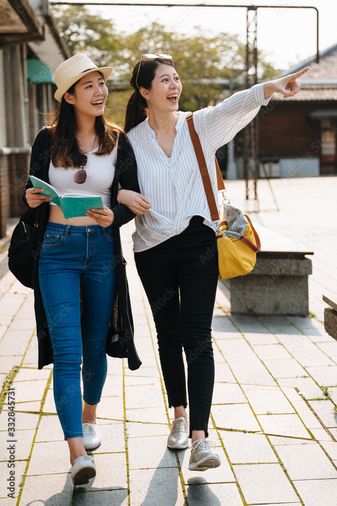两位亚洲华人旅行女朋友暑假带着导游在老城区散步