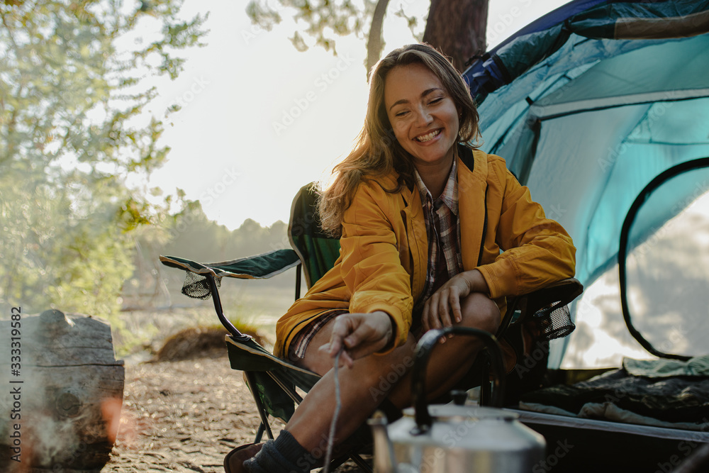 Smiling woman sitting at campsite