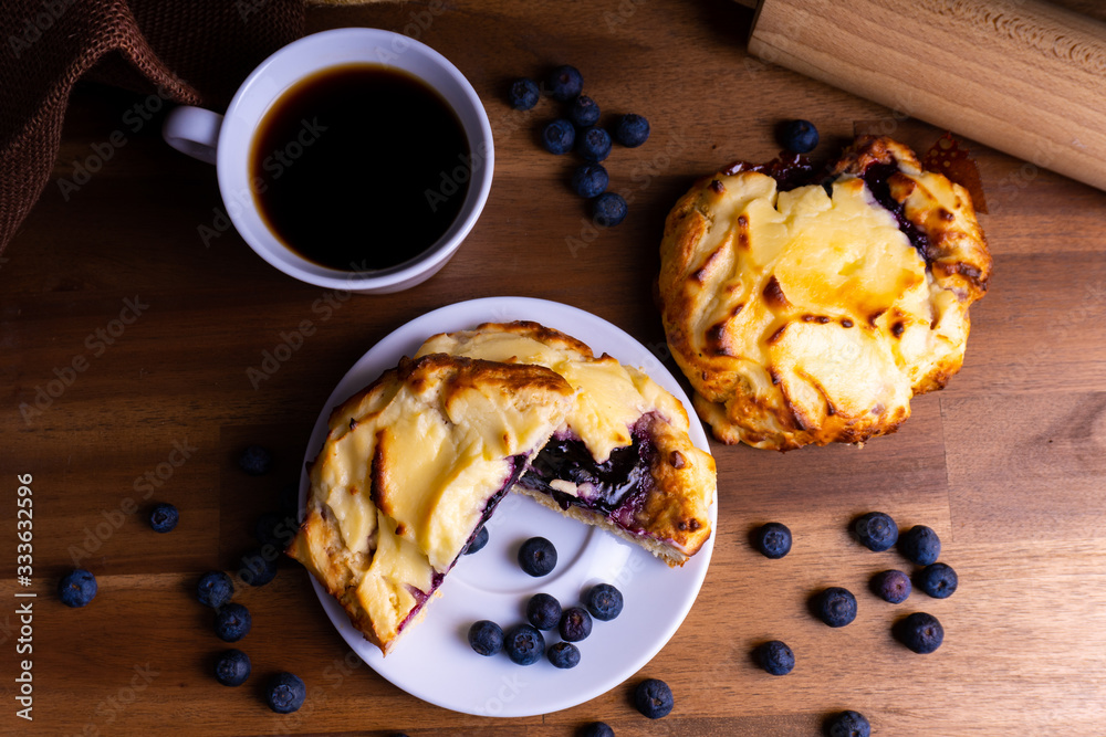 美味的芝士蛋糕饼干蛋糕配蓝莓和一杯放在木板上的咖啡，上面有复制品