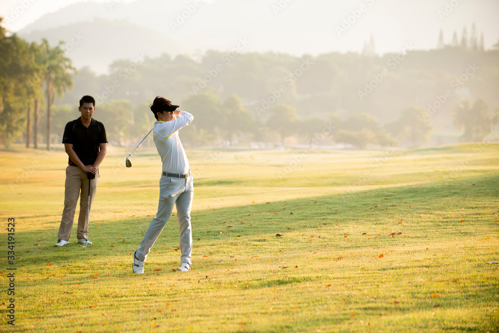 亚洲男子高尔夫球手与朋友在高尔夫球场打高尔夫