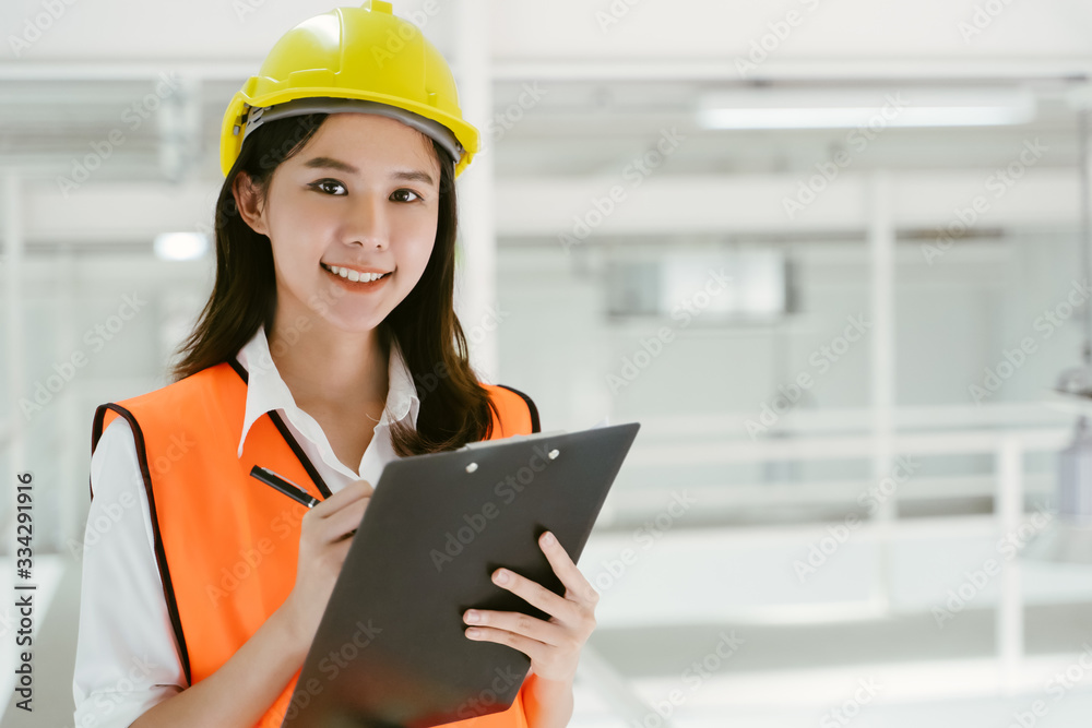 Portrait of Asian engineer female worker working at industry wear helmet hardhat and wear safety jac
