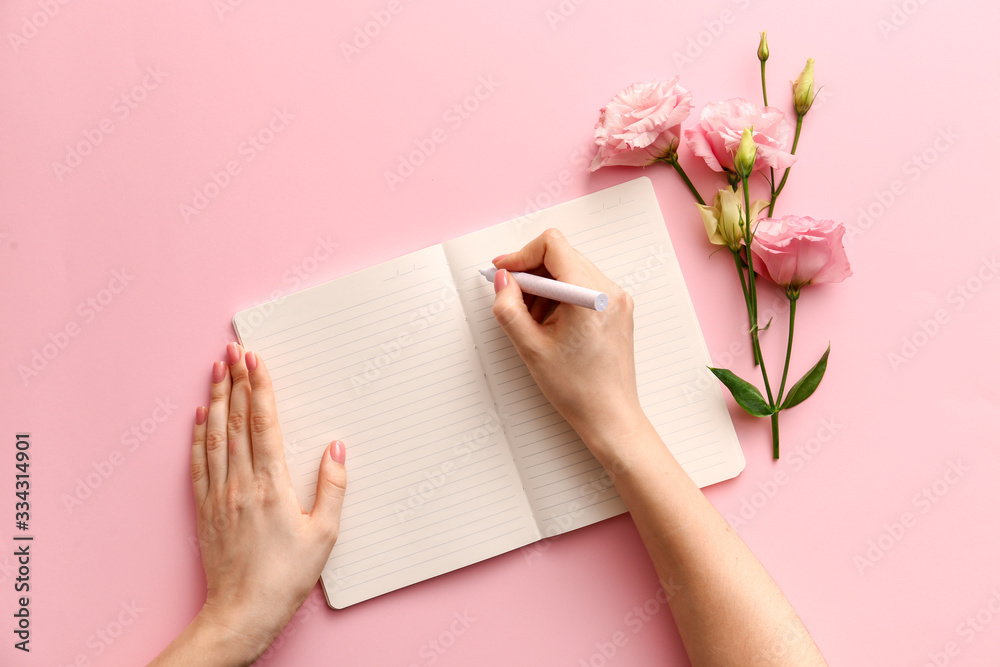 女人在彩色背景的笔记本上写东西