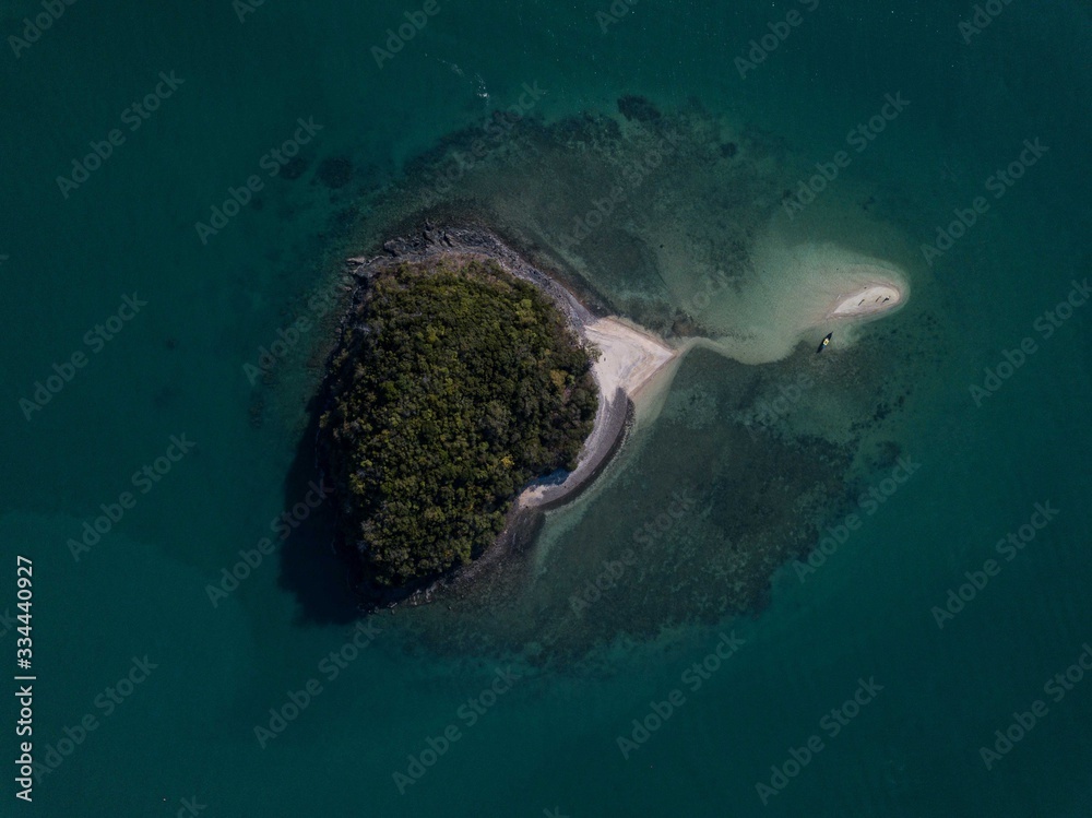 Aerial view: Tropical small island looks like heart with white sand beach in the sea, travel concept