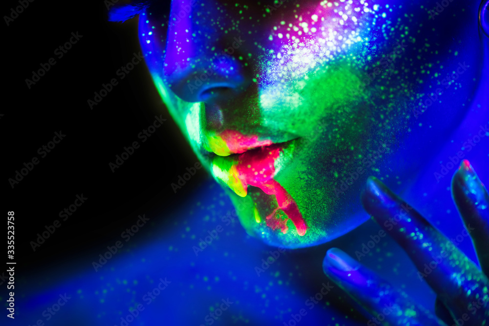 Neon paint lips and face, Fashion model woman in neon light, beautiful model girl lips with colorful