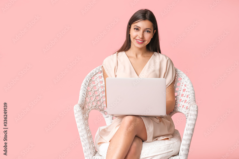 彩色背景下带笔记本电脑的年轻女性