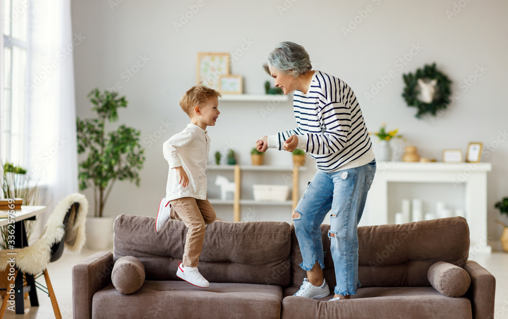 祖母和孙子在沙发上跳舞。