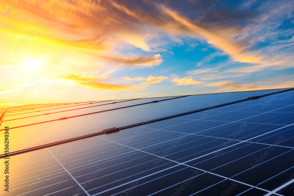 日落天空背景下的光伏太阳能电池板，绿色清洁能源概念。