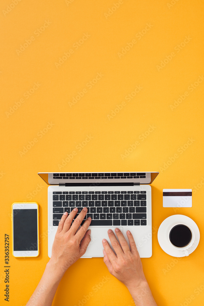 女商人正在用手机、信用卡和咖啡杯在电脑键盘上打字
