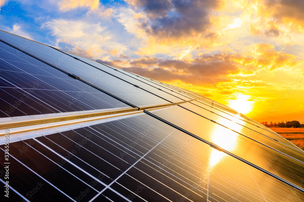 日落天空背景下的光伏太阳能电池板，绿色清洁能源概念。