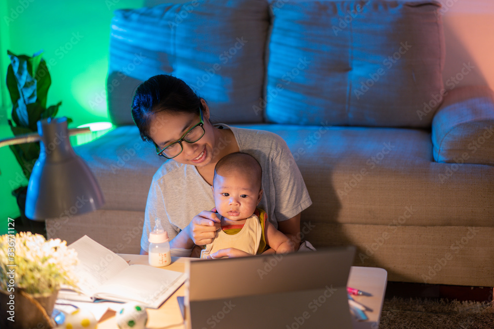 Asian mother and child Sitting and working at home at night