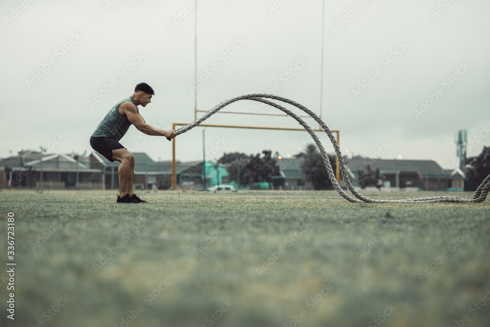 Athlete working out with battle ropes outdoors