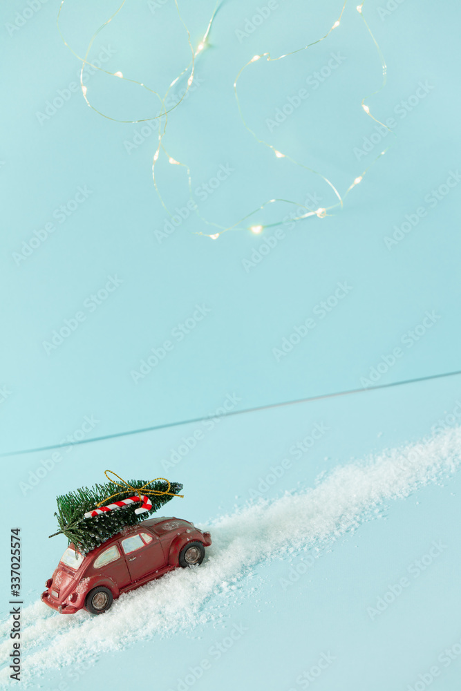 带圣诞树的红色玩具车，蓝色背景，带圣诞灯