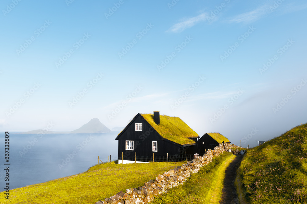 斯特里莫Velbastadur村一栋典型草坪顶草屋顶的房子的雾蒙蒙的晨景