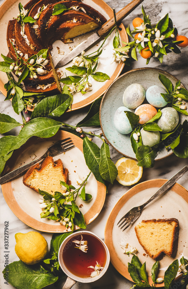 复活节假期餐桌设置。五颜六色的复活节彩蛋，柠檬蛋糕配柑橘树b