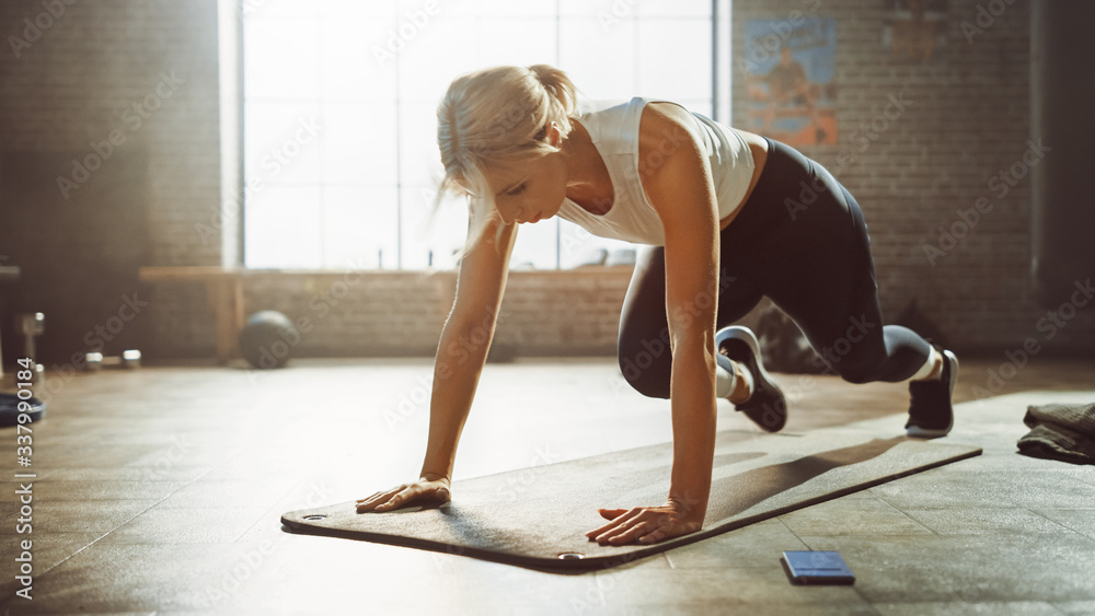 美丽而年轻的女孩在健身垫上做跑步平板运动。运动女性做登山运动