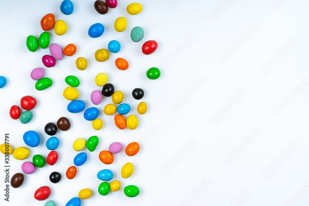 白色背景上散落的彩色糖果。明亮的圆形糖果。