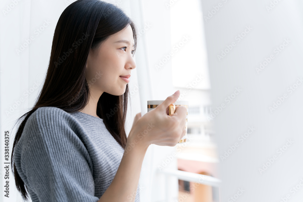 Portrait Asian beauty woman relaxing with coffee at home .Girl and coffee tea in the morning at wind