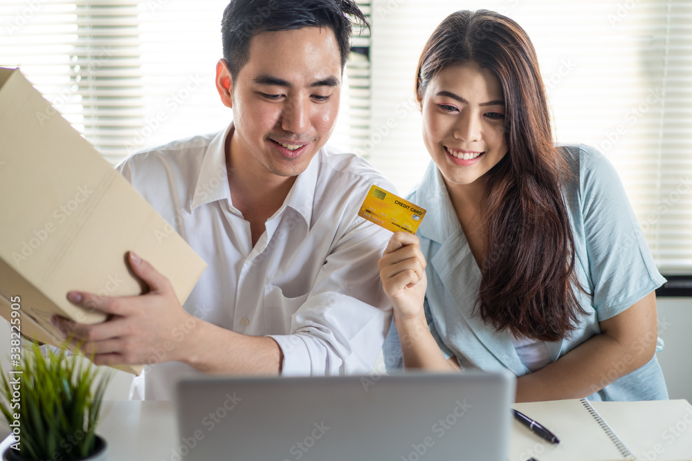 电子商务和在线购物概念。亚洲年轻夫妇使用信用卡从网站在线购买