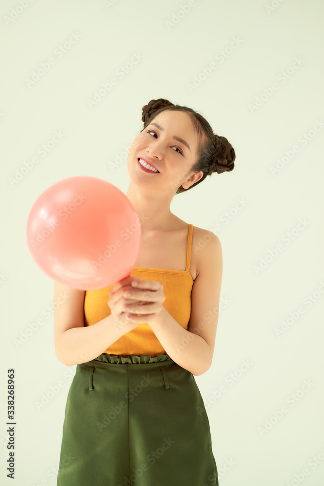 在浅色背景下，迷人可爱的吉尔拿着气球的肖像。
