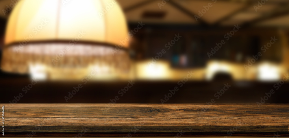 模糊的酒吧背景或带有灯光和背景的餐厅背景前的空木桌
