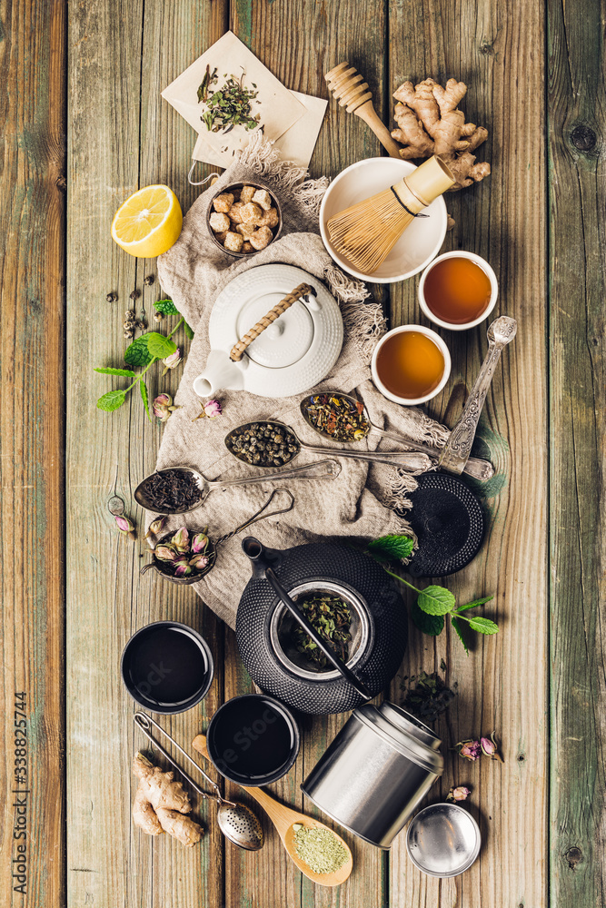 Various tea and teapots composition, dried herbal, green, black tea and matcha tea on wooden table b