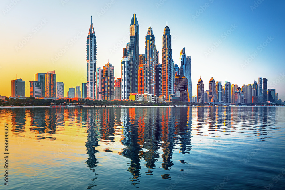 Modern and Luxury Dubai Marina with reflection - famous Jumeirah beach at sunrise, United Arab Emira