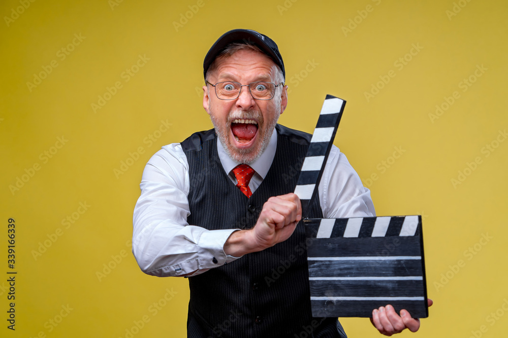 Senior man holds film flap close up. Film directing. Film production. Human emotions. Man with movie