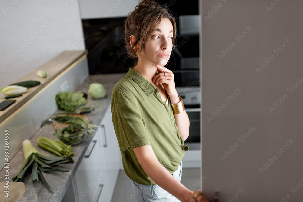 Young woman looking into the fridge, feeling hungry at night
