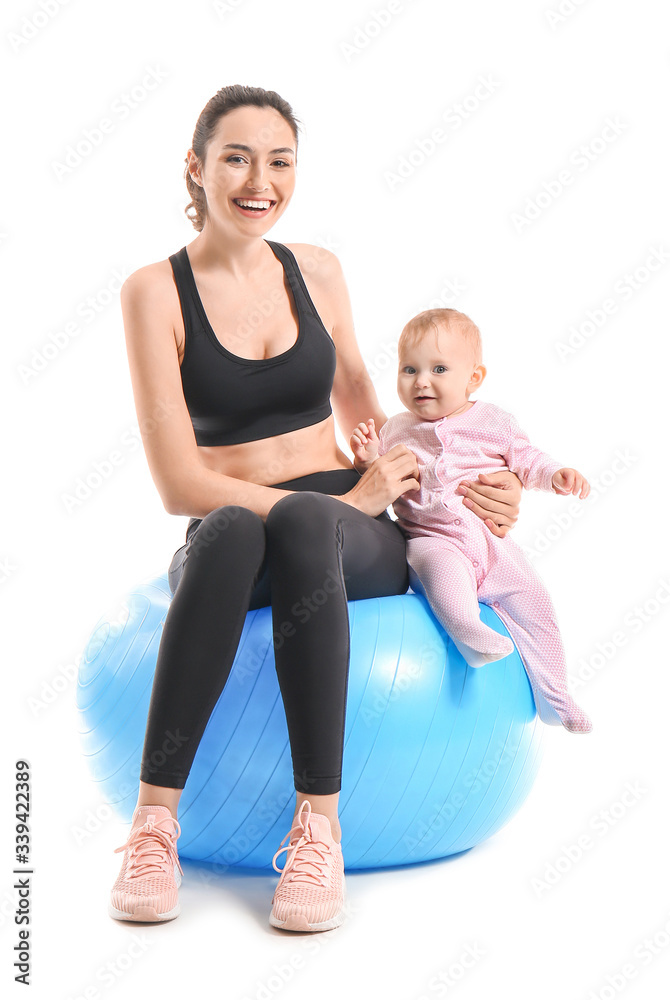 年轻的运动妈妈和她的宝宝在白色背景下用健身球做运动