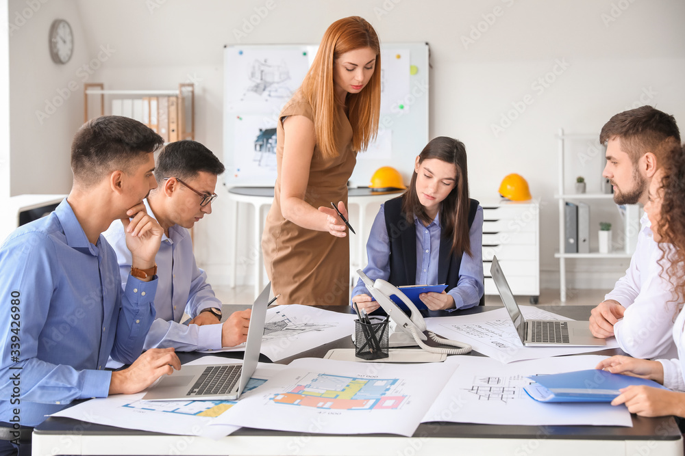 Architect teaching young people in office