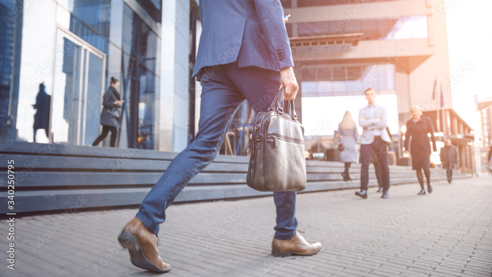 Close Up Leg Shot of a Businessman in a Suit Commuting to the Office on Foot. Hes Carrying a Leathe