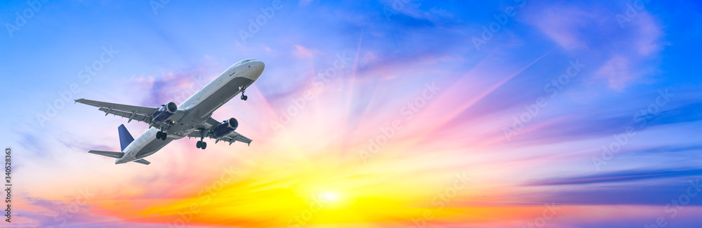 日落时分，商用飞机在美丽的天空中飞行，旅行理念。