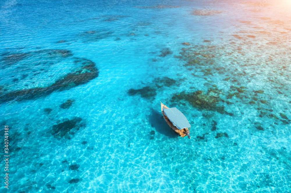 夏季日落时，渔船在清澈的蓝色水中的鸟瞰图。游艇的无人机俯视图
