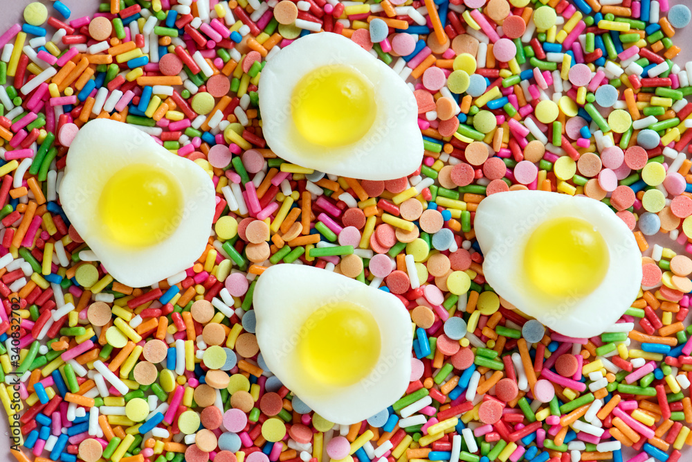 Flatlay of jelly fried eggs and sprinkles textured background