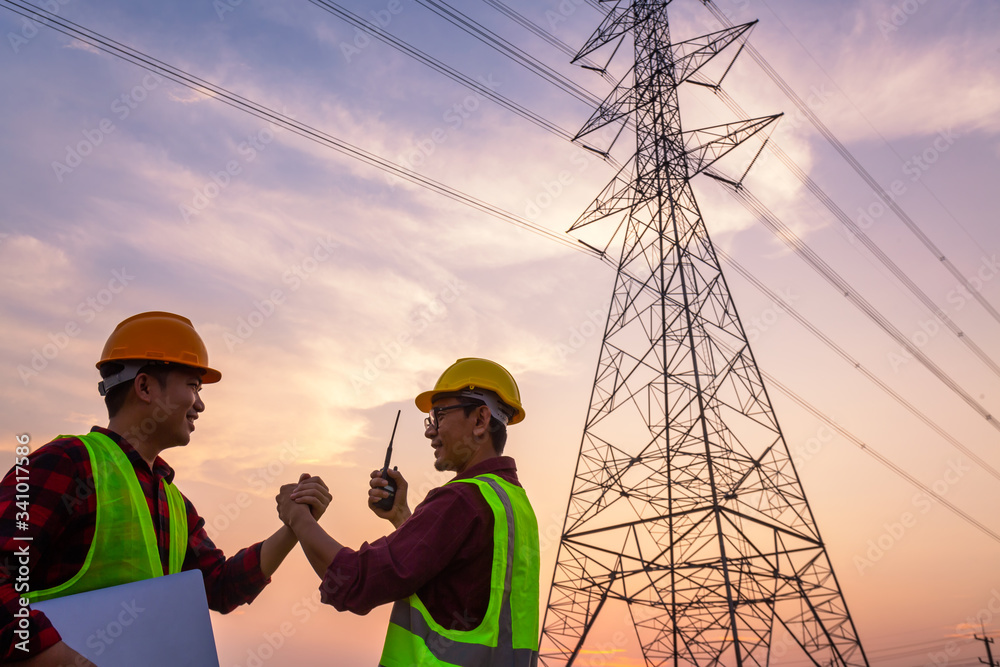 Asian Manager Engineering and worker in standard safety uniform working inspect the electricity high