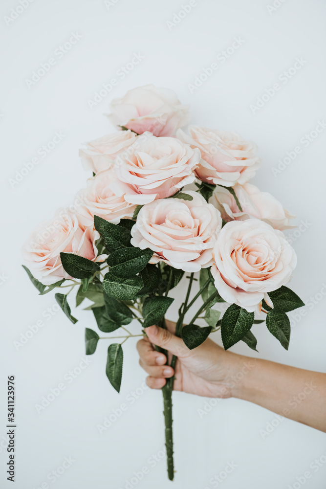 手拿一束柔和的橙色玫瑰