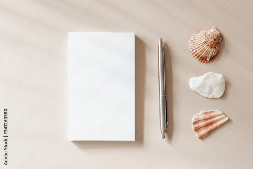 米色背景的空白笔记本页面和笔