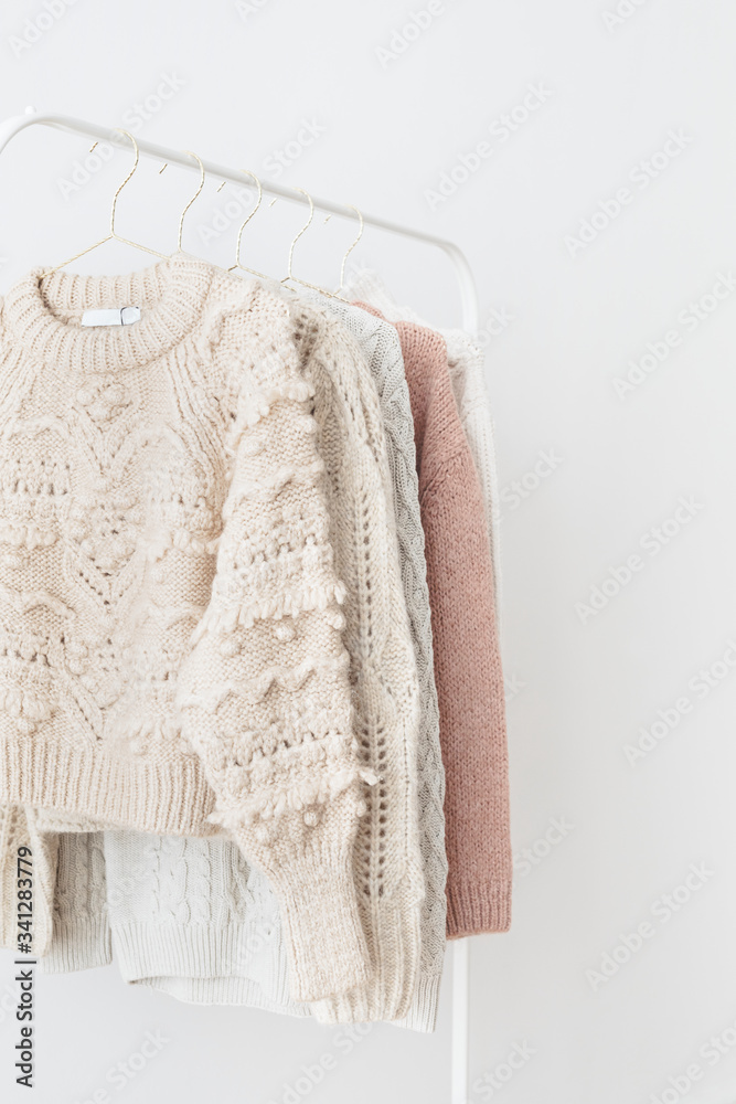 Casual knitted sweaters hanging on a rack