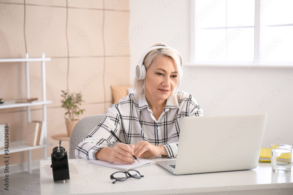 成熟女性在家使用笔记本电脑进行在线学习