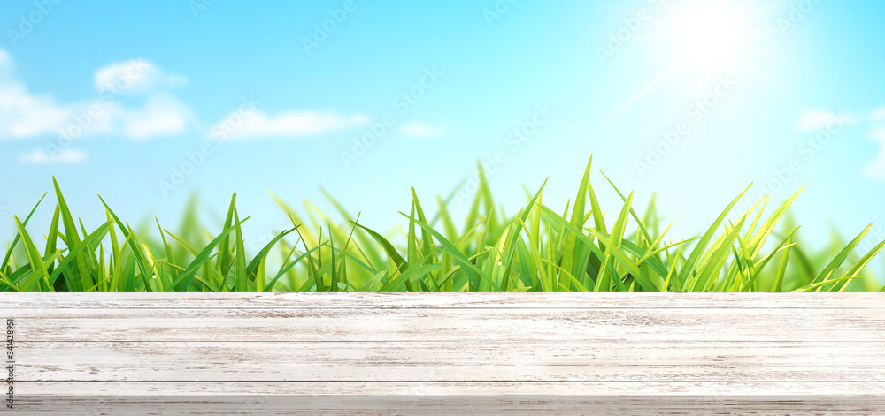 春天的背景是新鲜的草和白色的木桌。背景是春天的苹果园