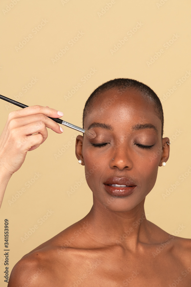 化妆师在黑人女性身上涂抹眼影