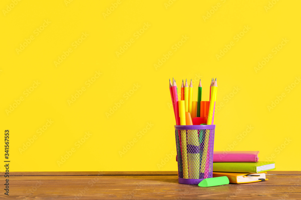 彩色背景下桌子上有文具的支架