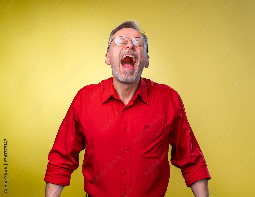 Senior man is standing with open mouth and closed mouth. Isolated against yellow background. Happy e