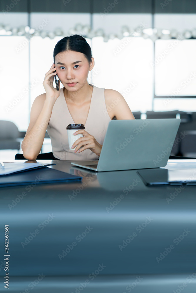 美丽的亚洲女性放松身心，用热饮咖啡和笔记本电脑看书